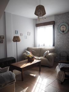 ein Wohnzimmer mit einem Sofa und einem Couchtisch in der Unterkunft Las Calendas de Atapuerca CB in Castrillo del Val