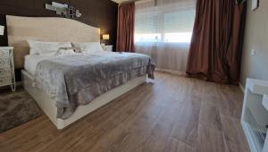 a bedroom with a large bed and a window at Sunset Apartment in Huelva