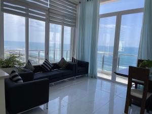 コロンボにあるLovely Sea View Apartmentのソファと大きな窓のあるリビングルーム