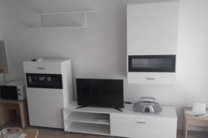 ein Wohnzimmer mit einem Flachbild-TV und einem TV-Stand in der Unterkunft Apartman Ivan in Kaštela