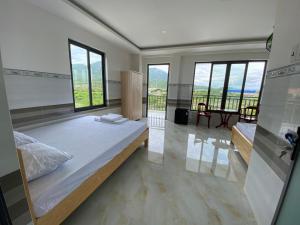 a large bedroom with a large bed and large windows at Hải Phong hotel in My Luong