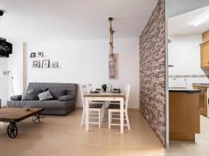 een woonkamer met een tafel en een bakstenen muur bij Adorable apartment 60m from the beach WIFI in Puerto de Sagunto