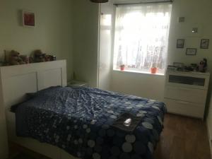 una camera da letto con un letto con un piumone blu e una finestra di Norfolk House a Londra