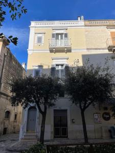 een gebouw met een balkon en twee bomen ervoor bij La Finestra sul Teatro in Gioia del Colle