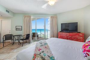 a bedroom with a bed and a television and a table with chairs at Sterling Sands 514A in Destin