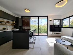kuchnia i salon z kanapą i stołem w obiekcie 8 Hulda - By Beach Apartments TLV w Tel Awiwie