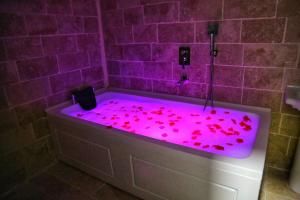 a bathroom with a pink bath tub filled with red petals at Whitestone Hotel in Nevsehir
