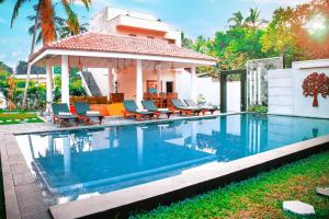 a swimming pool in front of a house at Tree of Life Resort in Bentota