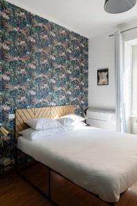 a bedroom with a large bed with a floral wallpaper at Domus Vaticana in Rome
