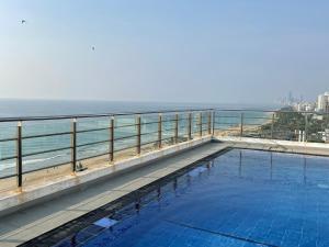 a swimming pool with the ocean in the background at Lovely Sea View Apartment in Colombo