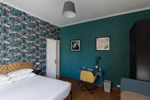 a bedroom with a bed and a desk and green walls at Domus Vaticana in Rome