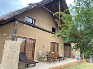 ein Haus mit einer Terrasse, einem Tisch und Stühlen in der Unterkunft Luna Piena 19A Zebula golf course and spa resort in Mabula