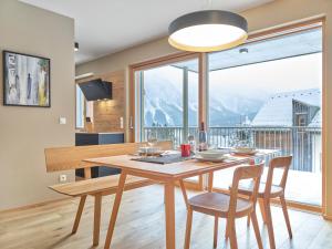 ein Esszimmer mit einem Tisch und Stühlen sowie einem großen Fenster in der Unterkunft Mountain Lover two in Tauplitz