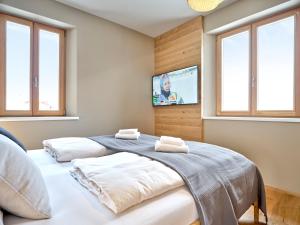two beds in a bedroom with a tv on the wall at Mountain Lover two in Tauplitz