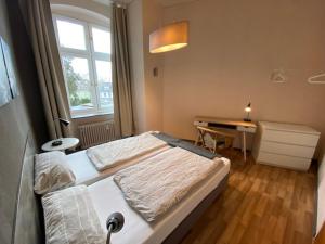 1 dormitorio con cama, escritorio y ventana en Apartments Starlight Hotel Wiesmann, en Bochum