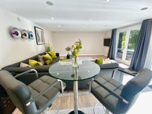 uma sala de estar com um sofá, uma mesa e cadeiras em Sunridge Fishing Lodge with Hot Tub & Giant Cinema em Plymouth