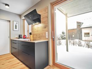 a kitchen with a sink and a large window at Mountain Lover one by AA Holiday Homes in Tauplitz