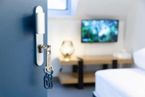 a door with a key in a room with a bed at Hotel Victoria in Strasbourg