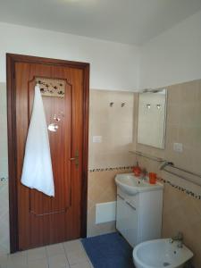 ein Badezimmer mit einem WC und einer Holztür in der Unterkunft Casa Parco Aranci in Formia
