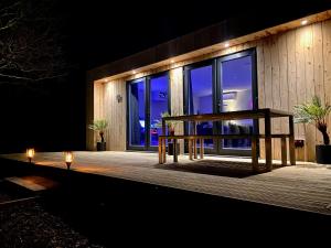 una terraza de madera con dos velas por la noche en Sunridge Fishing Lodge with Hot Tub & Giant Cinema, en Plymouth