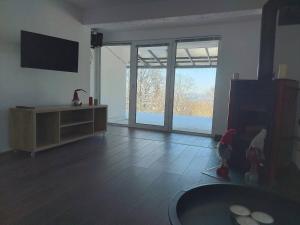 a living room with a television and a large window at Apartmani Milosevic in Kopaonik