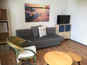 sala de estar con sofá, mesa y TV en Apartments Starlight Hotel Wiesmann, en Bochum