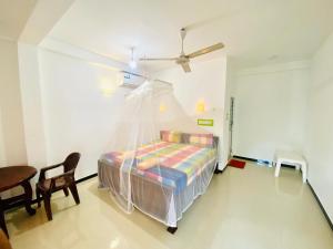 una camera da letto con un letto con zanzariera di Inu Vicky Beach Hotel a Tangalle