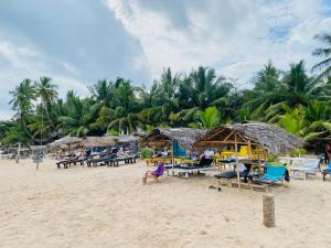 una spiaggia con sedie e ombrelloni sulla sabbia di Inu Vicky Beach Hotel a Tangalle