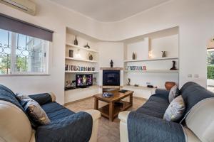 a living room with two couches and a tv at Celina by Algarve Villa Holidays in Guia