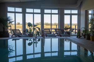 a room with a pool with chairs and windows at FerienDüne "Riedensee" in Kühlungsborn