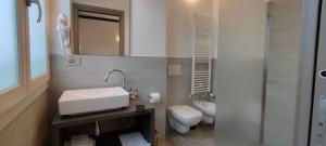 a bathroom with a sink and a toilet and a mirror at Suites Direzionale Carpi in Carpi