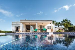 a villa with a swimming pool in front of a house at Celina by Algarve Villa Holidays in Guia