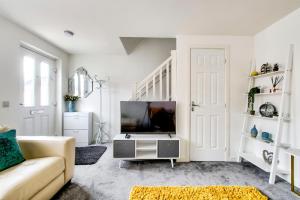 sala de estar con sofá y TV en 2-Bedroom Holiday Home With Private Garden & Parking, en Edimburgo