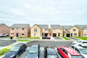 a parking lot in front of a row of houses at 2-Bedroom Holiday Home With Private Garden & Parking in Edinburgh