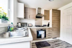 cocina con fregadero y fogones en 2-Bedroom Holiday Home With Private Garden & Parking, en Edimburgo