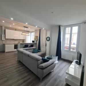 een woonkamer met een bank en een keuken bij Appartement très lumineux porte de Saint-Cloud - F3 avec suite parentale in Parijs