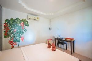 um quarto com uma cama e uma mesa com um quadro em Phi Phi Cozy Seafront Resort em Phi Phi Don