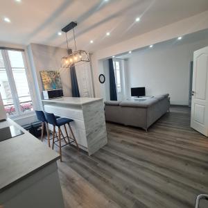 een woonkamer met een bureau en een bank bij Appartement très lumineux porte de Saint-Cloud - F3 avec suite parentale in Parijs