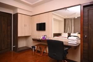 Habitación de hotel con escritorio y cama en HOTEL CENTER POINT en Solapur