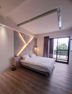um quarto com uma cama grande e uma janela grande em 台東有點田民宿 em Guanshan