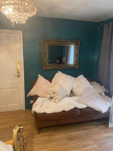 a room with a couch with pillows and a mirror at The Big Cosy Boudoir Bed + Hot tub in Harvington
