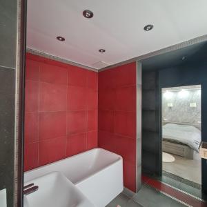 een rode badkamer met een bad en een slaapkamer bij Appartement très lumineux porte de Saint-Cloud - F3 avec suite parentale in Parijs