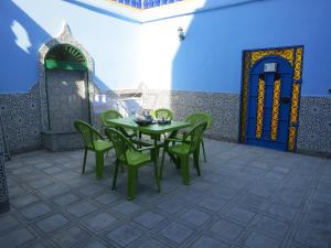 einen grünen Tisch und Stühle auf einer Terrasse in der Unterkunft Casa Morisca Sidi Ifni in Sidi Ifni
