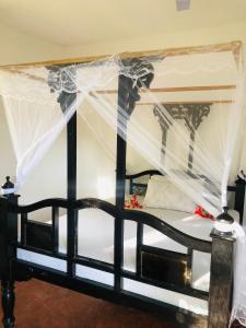 a black and white bed with a canopy at The Dream Garden Bungalow in Kizimkazi