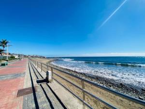 una panchina seduta su una spiaggia vicino all'oceano di Los Balandros 116 a San Agustin