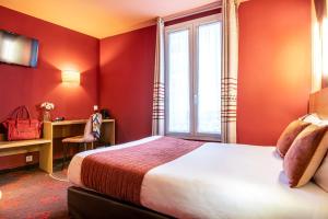 パリにあるホテル アリアンヌ モンパルナス バイ パトリック ハヤットのベッド、デスク、窓が備わるホテルルームです。