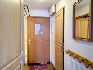 ein Badezimmer mit einer Holztür und einem Spiegel in der Unterkunft Appartement Les Menuires, 3 pièces, 6 personnes - FR-1-178-310 in Les Menuires