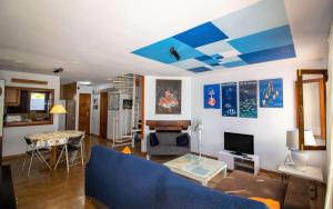 a living room with a blue couch and a table at Adosado con piscina a 50 metros de la playa - Las Fuentes ALBERT VILLAS in Alcossebre