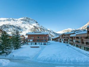 un complexe avec des montagnes enneigées en arrière-plan dans l'établissement Appartement Val-d'Isère, 3 pièces, 5 personnes - FR-1-519-22, à Val dʼIsère