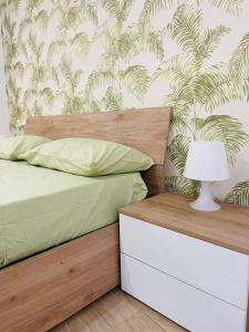 1 dormitorio con 1 cama con mesita de noche y lámpara en La Casa di Nonna Cristina, en Castellammare di Stabia